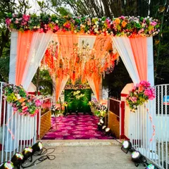 A bright and cheerful entrance for an engagement ceremony. We used peach and white drapes, a colorful floral arch, and a carpet of purple to create a welcoming and festive walkway.