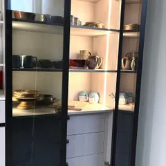 This view highlights the vertical LED strip lighting inside the crockery cabinet. This feature not only illuminates your dinnerware but also adds a warm, ambient glow to the room, turning storage into a display.