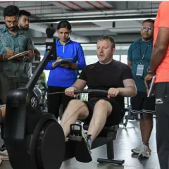 Day 1 focuses on fundamentals. Here, UKSCA trainer Martin Gallyer demonstrates correct rowing machine technique, a key component of conditioning, while participants observe and take notes.