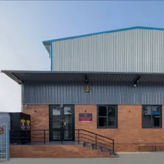 The exterior of the GOAT Club combines an industrial metal shed with a warm, welcoming exposed brick base that houses the lounge and changing rooms.