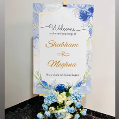 An elegant welcome sign for a Roka ceremony, designed with a blue floral and marble theme to match the couple's decor.