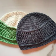 A pair of Sheldon beanies in green and cream, and a solid charcoal grey. The Alpine stitch provides wonderful texture and warmth, making it a very practical winter hat.