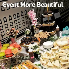 Let me make your hi-tea event more beautiful with an exquisite spread like this. This table features colorful macarons, mini sandwiches, chocolate donuts, and savory bites, creating an unforgettable experience.