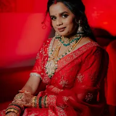 A stunning portrait of the bride in her vibrant red reception lehenga, showcasing her intricate jewelry and makeup. I use dramatic lighting to create these glamorous shots.