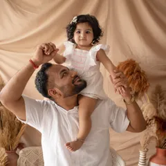 A playful father-daughter moment. A shoulder ride is always a fun way to capture genuine smiles and a loving connection.