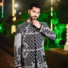 A confident pose in our black and ivory embroidered jacket. The contrast between the dark fabric and the light embroidery makes this a visually striking piece for any special occasion.