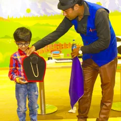 A child volunteer helps the magician with a classic disappearing act. Our entertainers are great at involving the kids in the show.