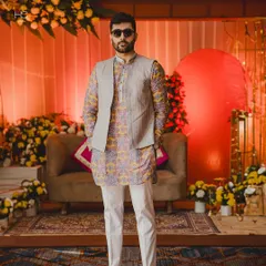 This full-length view shows how the printed kurta and solid bundi combination creates a sharp, celebratory outfit perfect for a sangeet or mehendi.
