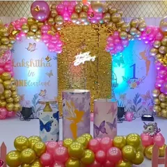 A stunning butterfly theme called "Lakshitha in ONEderland". This setup features a gold sequin backdrop, pink and gold balloon arches, and whimsical butterfly details for a magical first birthday.