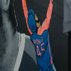 A close-up of the smaller, full-color figure celebrating in the Rohit Sharma mural. The contrast between the monochrome portrait and the colorful character makes the whole piece stand out.