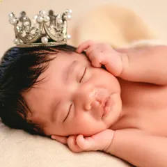Another variation of the classic posed portrait. This close-up captures the sweet, sleepy smile and the baby's tiny hands framing their face.