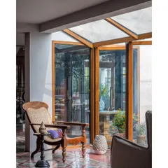 This quiet corner in the Dhaka residence is a perfect example of how light changes a space throughout the day. The antique-style chair, which traveled from Cochin, sits by a glass enclosure, blurring the line between inside and out. The patterned flooring was sourced from Mumbai, adding another layer to the home's story.