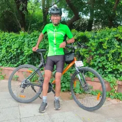 A rider in a bright green jersey, smiling for the camera. Our members' individual personalities make our group vibrant.