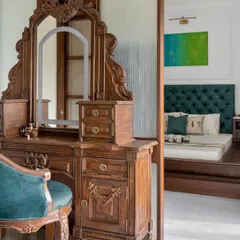 This vintage-inspired vanity, separated from the master bedroom by an ombre glass partition, is a perfect example of classic elegance. The intricate carvings and rich wood finish add a touch of old-world charm and create a dedicated, luxurious space for getting ready.