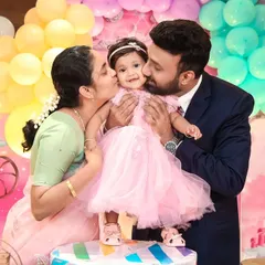 These are the moments we live for. We captured this beautiful, candid moment of parents sharing a kiss with their daughter on her first birthday, surrounded by a dreamy Cinderella-themed decor. Our goal is to freeze these precious family memories in time.