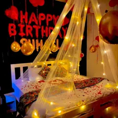 For a truly special birthday surprise, I design romantic bedroom decorations like this. The setup includes a delicate canopy, warm fairy lights, scattered rose petals, and a combination of foil and latex balloons to create a cozy and love-filled ambiance.