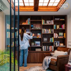 Another view of the home library, showing how the space is both functional for storage and inviting for relaxation. The warm wood and classic furniture create a timeless and scholarly atmosphere.
