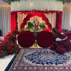 For an intimate home celebration, we designed this stunning floral mandap using thousands of red roses. The mirrored floor adds a touch of glamour, reflecting the vibrant decor and creating a truly immersive worship space.