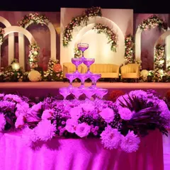 A classic champagne tower set against a stunning floral stage we designed for a wedding reception. This timeless feature adds a touch of glamour and makes for a perfect photo opportunity.