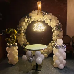 Here’s a chic and modern setup perfect for any adult celebration. This design features a full balloon arch in a classy white and chrome silver palette, a stylish cake table, and a custom neon "Happy Birthday" sign that glows for the perfect party vibe.