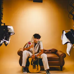 A wider shot of the musician's portrait session, revealing the lighting setup used to create this moody, intimate feel.
