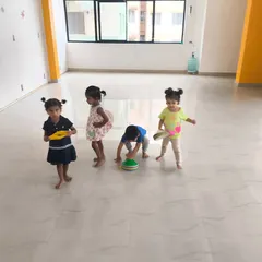 Kids play with sports equipment in our spacious indoor studio. This free play moment helps them develop motor skills and social interaction in a structured environment.