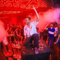 Surrounded by red lights and CO2 smoke, I love getting right into the middle of the action. This is me on top of a speaker, making sure the energy reaches every corner of the club.