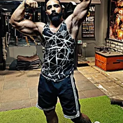 Defying limits and embracing strength. An athlete showing his classic physique pose in the gym, a testament to his hard work and our guidance.