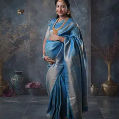 Elegance in blue. This stunning blue silk saree with a silver border looks absolutely regal. We paired it with traditional gold jewelry and a classic temple-themed backdrop for a sophisticated portrait.