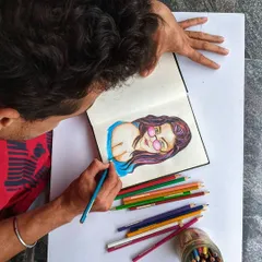 Here I am working on a colorful portrait with colored pencils. This behind-the-scenes view shows the focus and care that goes into every illustration.