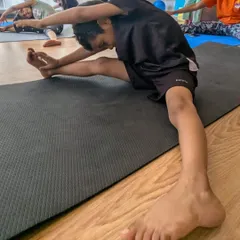 A student works on a seated side stretch during a yoga and flexibility session. We incorporate elements of yoga to improve flexibility, balance, and focus in our young athletes.