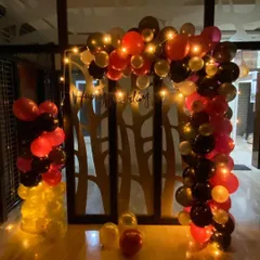 This birthday party decoration combines bold red, black, and gold balloons to create a dramatic and festive arch. I added fairy lights to the arrangement to give it a warm glow, making the celebration feel extra special after dark.