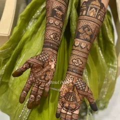 A complete view of a custom bridal mehndi featuring bride and groom figures. The design includes palace architecture and auspicious symbols like 'Om' and the swastika, creating a narrative that is both personal and traditional.
