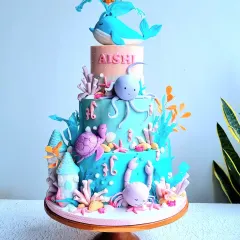 An imaginative four-tier underwater fantasy cake, perfect for a big celebration. The design features a variety of sea creatures like a friendly whale, octopus, and turtle, all handcrafted from fondant and set against a beautiful ocean-colored cake, creating a vibrant deep-sea adventure.