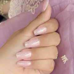 A lovely set of coffin-shaped nails with a soft, shimmery pink gel polish, perfect for an everyday elegant look.