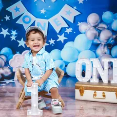 Look at that happy face! This little boy is celebrating turning one with our starry blue theme, complete with balloons and a light-up "ONE" sign.