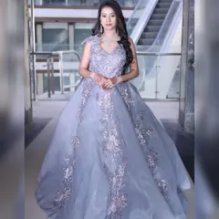 A fairytale gown in a lovely lavender-grey shade. The tulle skirt is adorned with delicate floral appliqué, making it a dreamy choice for a reception or pre-wedding shoot.