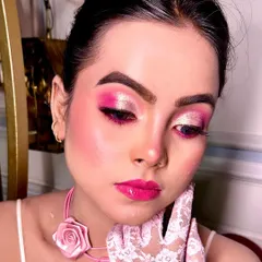 A close up of the Barbie inspired makeup look. The dual-toned pink and shimmer eyeshadow, glossy pink lips, and rosy cheeks create a playful and glamorous vibe.