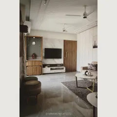 In this living room, we combined a marble-clad media wall with a wooden pooja mandir. This creates a harmonious balance between modern aesthetics and traditional values, all within a clean and uncluttered layout.
