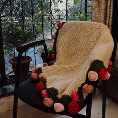This is my rose bouquet blanket, a true passion project. I stitched 32 individual roses onto this cozy, cream-colored blanket, creating a piece that is both functional and a work of art. It’s perfect for draping over a chair or snuggling up with.