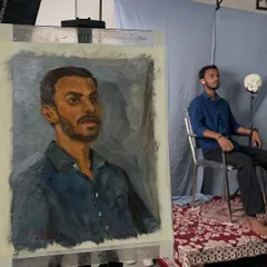 This is what a live portrait session looks like. Here, you can see the finished oil portrait of Satyam on the easel, with him posing in the background. These sessions are an immersive experience where we work together to create something truly personal.