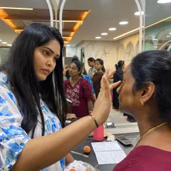 In my self-grooming classes, I provide direct, hands-on guidance. Here, I'm showing a student the correct placement for concealer to brighten the under-eye area without it looking heavy.