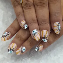 Express your unique style with our custom hand-painted nail art. This design features the popular evil eye motif, detailed with fine lines and gold glitter accents on a natural, almond-shaped nail.