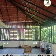 This spacious veranda is covered by a large Mangalore tile roof, creating a cool and sheltered outdoor living area. The slatted side panels provide ventilation while maintaining a sense of enclosure.