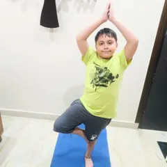 A young student finds his balance in tree pose (Vrikshasana). Yoga helps kids develop balance, concentration, and a deeper connection with their bodies.