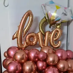 A beautiful tabletop balloon arrangement with 'Love' foil balloons and a diamond ring accent, perfect for an engagement or anniversary.