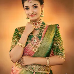 A beautiful South Indian bridal look with a focus on radiant skin and defined eyes, paired with a traditional green and pink Kanjeevaram saree.