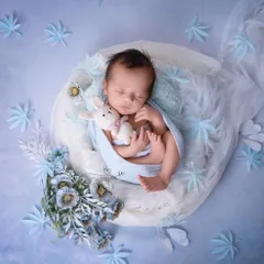 Wrapped in love and a touch of blue. This simple, elegant portrait focuses on the baby's peaceful sleep, with a soft bunny for comfort.