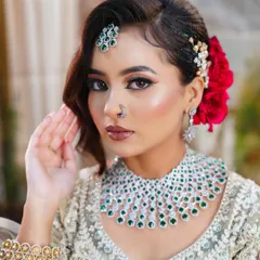 This portrait highlights the perfectly blended makeup and the striking contrast of the red rose against the elegant hairstyle.