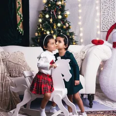 A sweet secret shared between sisters. This photo captures the special bond of siblings during the most wonderful time of the year.